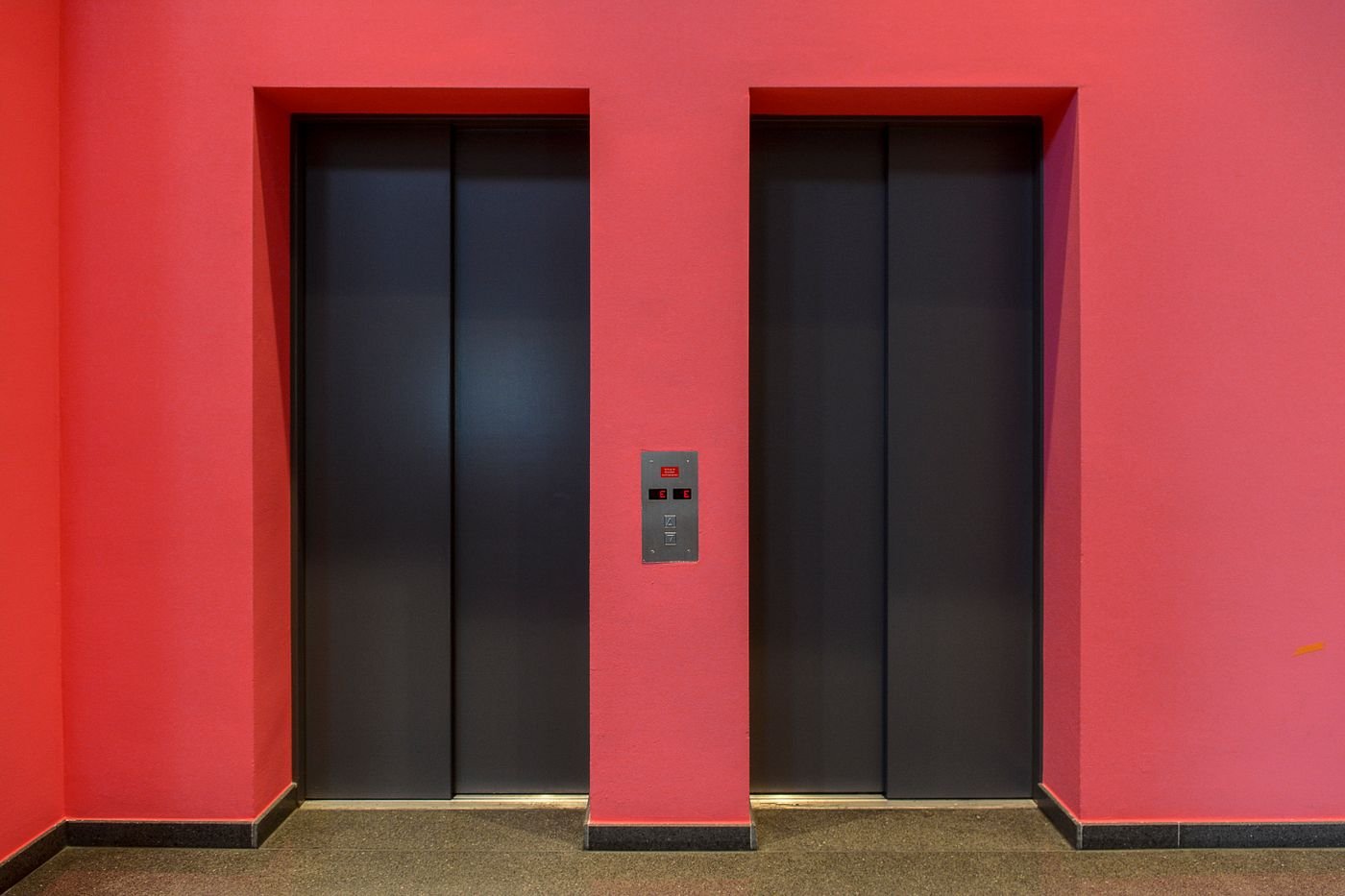 Batterie d'ascenseurs dans le hall d'un immeuble soumise aux visites périodiques réglementaires