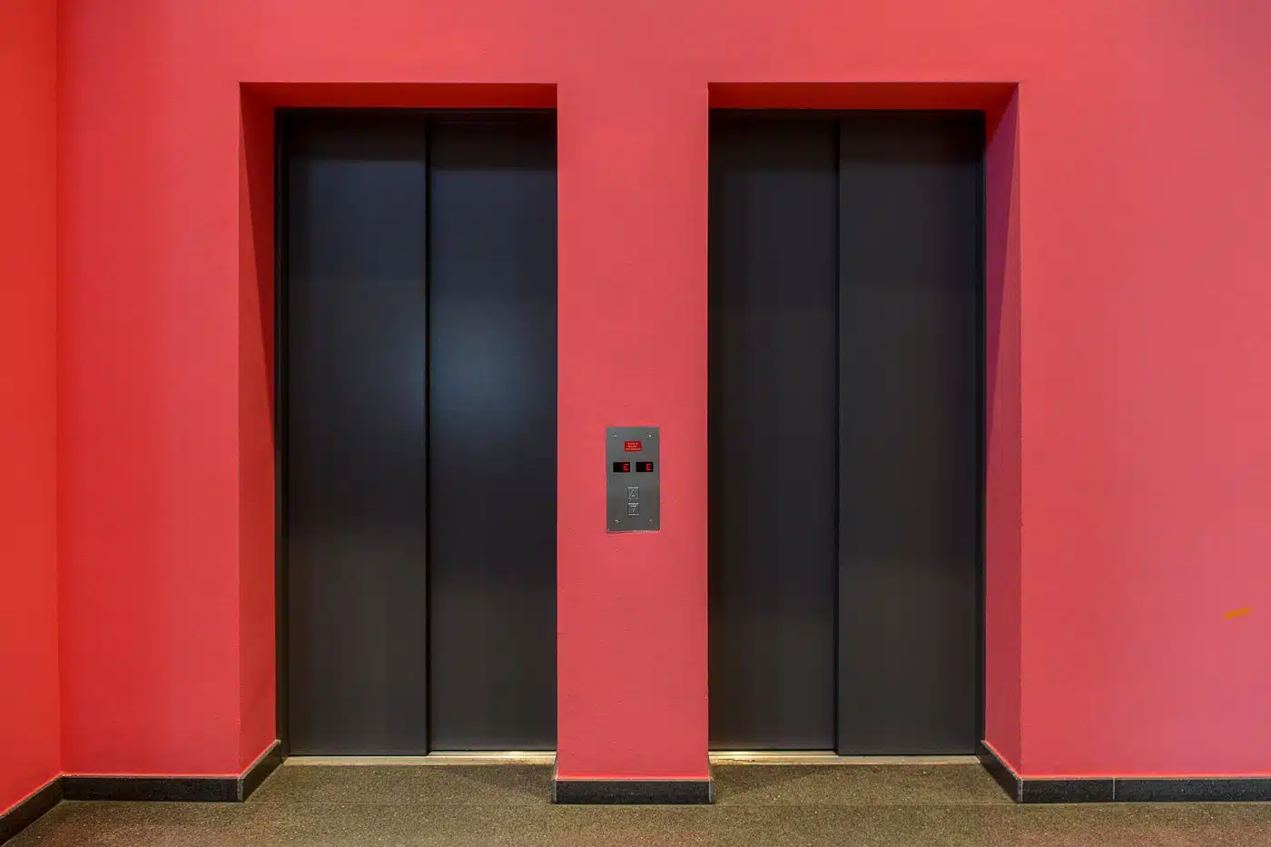 Batterie d'ascenseurs dans le hall d'un immeuble soumise aux visites périodiques réglementaires